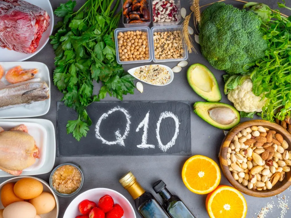 Flat-lay of foods that naturally contain CoQ10 arranged around a chalkboard labeled Q10