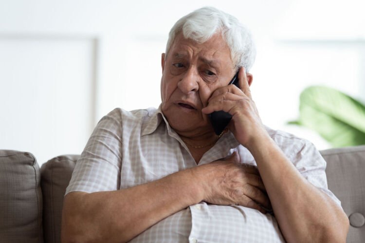 Older man looking concerned while on a phone call
