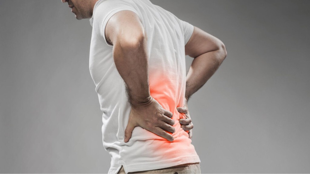 Man holding lower back with red heat-map indicating discomfort