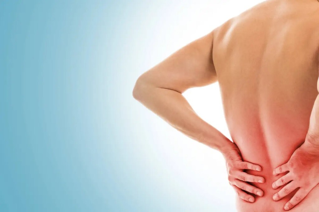 Person holding lower back with red glow indicating joint or muscle discomfort