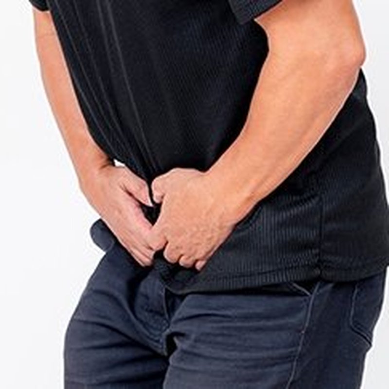 Man holding his lower abdomen, representing urinary urgency and nighttime bathroom trips