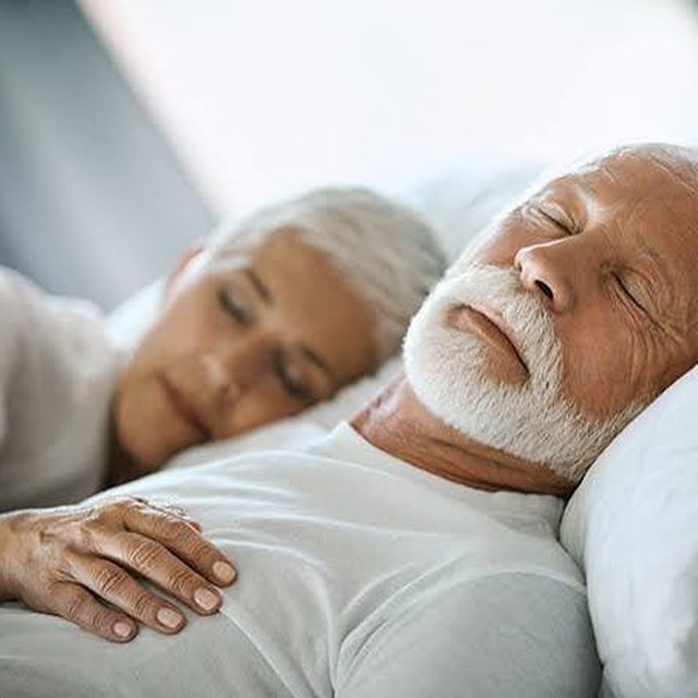 Older couple sleeping peacefully representing sleep and brain health after 40